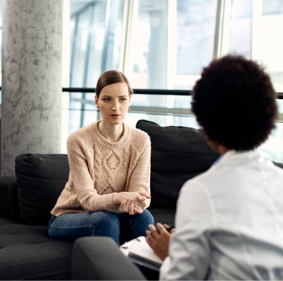 A woman sitting in a chair talking to a coach