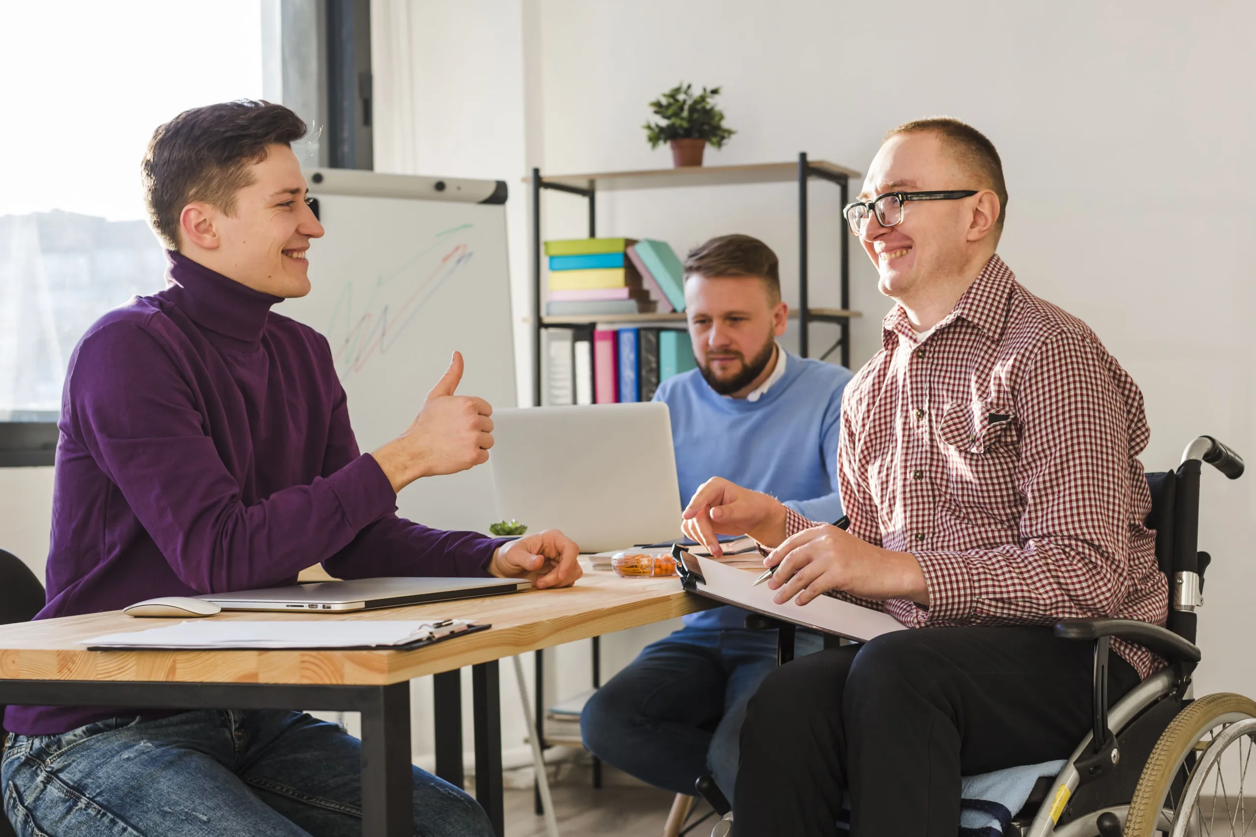 Three men discussing Psychology Services together in an office setting.